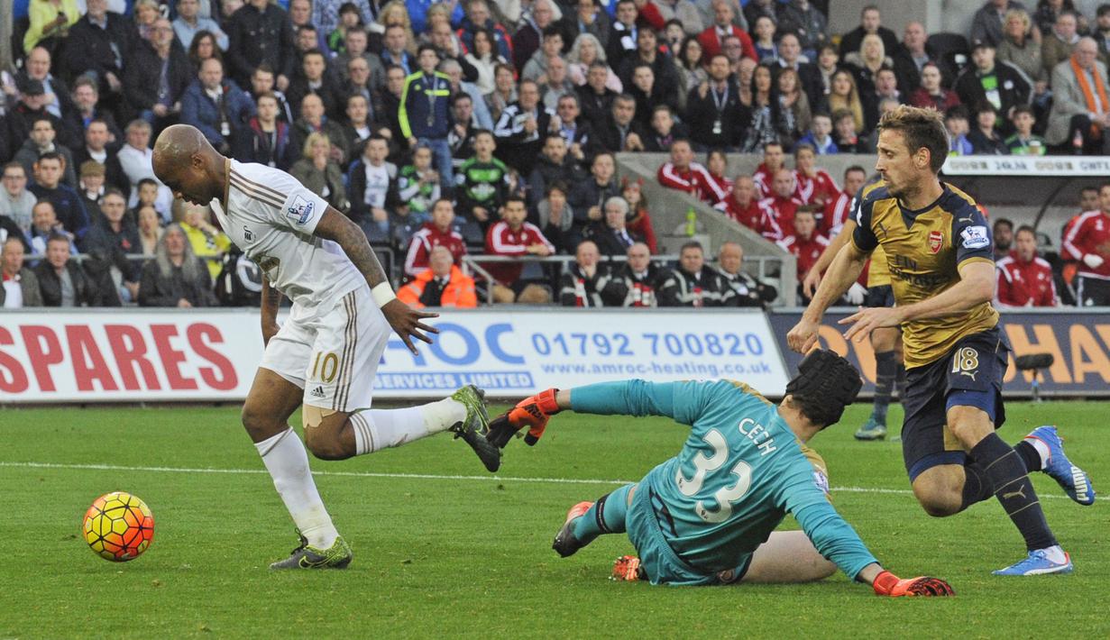 Pemain Swansea City, Andre Ayew berusaha melewati hadangan kiper Arsenal,  Petr Cech, dalam lanjutan Liga Premier Inggris di Stadion Liberty, Inggris, Sabtu (31/10/2015). (Reuters/Rebecca Naden)