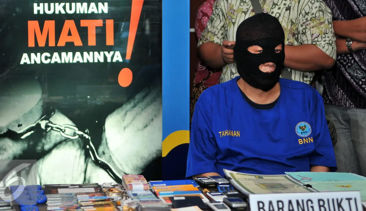 Tersangka berinisial GP dihadirkan saat gelar barang bukti Tindak Pidana Pencucian Uang (TPPU) narkotika di kantor BNN, Jakarta, Selasa (26/1). BNN berhasil menyita aset senilai Rp17 miliar di Tebing Tinggi, Medan. (Liputan6.com/Yoppy Renato)