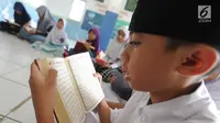 Anak-anak membaca kitab suci Al-Quran di Kampung Quran Alkholidin Cinere,  Depok, Senin (13/5/2019). Momentum bulan Ramadhan 1440 H dimanfaatkan anak-anak usai pulang sekolah untuk membaca dan menghapal Quran secara bersama-sama untuk menambah amalan ibadah puasa. (merdeka.com/Arie Basuki)