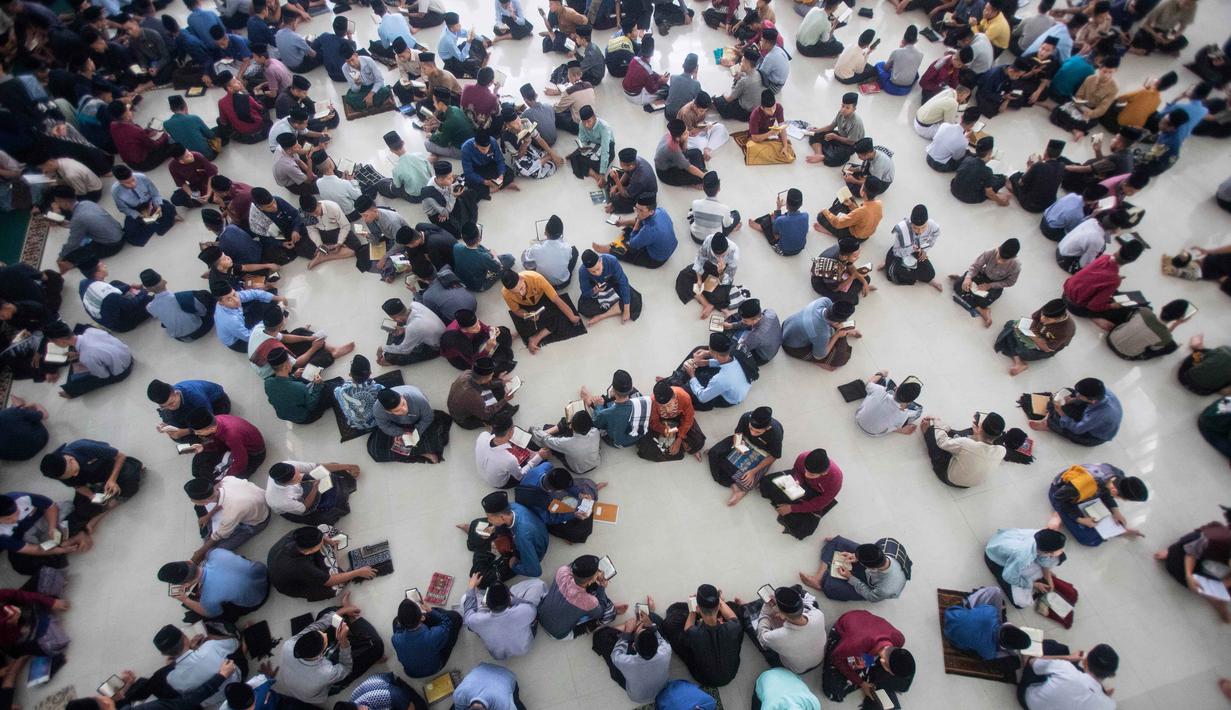 Selain memperkuat pemahaman dan kelancaran membaca Al Quran, tradisi ini juga menjadi sarana mempererat kebersamaan antar santri. Tampak dalam foto, para siswa duduk melingkar sambil membaca Al-Quran selama bulan suci Ramadan 1447 Hijriah di Pondok Pesantren Ar-Raudlatul Hasanah di Medan, Sumatera Utara, Sabtu 21 Februari 2026. (AP Photo/Binsar Bakkara)