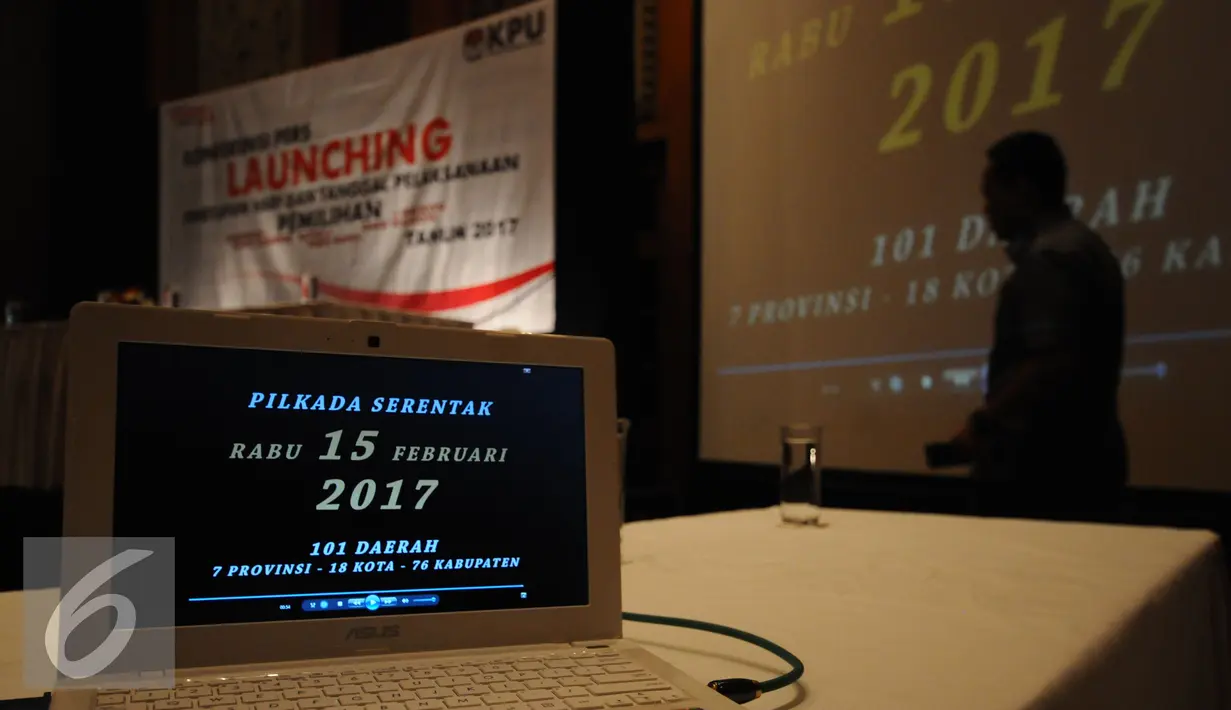 Petugas KPU melintasi layar monitor usai Launching Penetapan Hari dan Tanggal Pelaksanaan Pilkada Serentak 2017 di Jakarta, Senin (15/2/2016). Pilkada Serentak 2017 akan dilaksanakan Rabu 15 Februari 2017. (Liputan6.com/Helmi Fithriansyah)