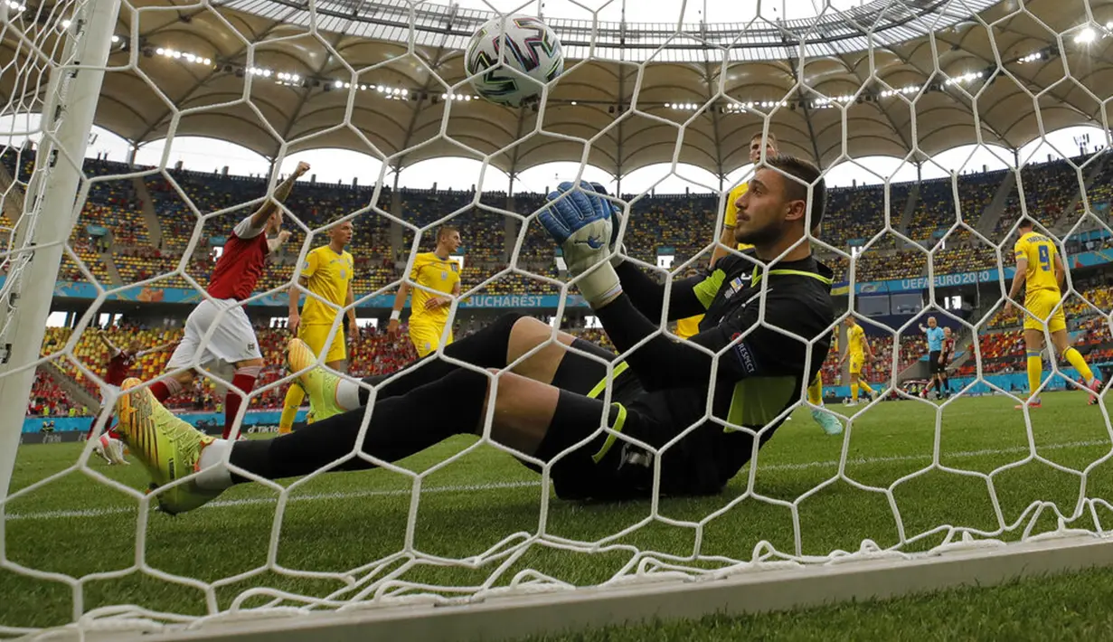 Penjaga gawang Ukraina Heorhiy Bushchan terduduk usai pemain Austria Christoph Baumgartner mencetak gol ke gawangnya pada pertandingan Grup C Euro 2020 di Stadion National Arena, Bucharest, Rumania, Senin (21/6/2021). Ukraina kalah 0-1. (AP Photo/Vadim Ghirda)