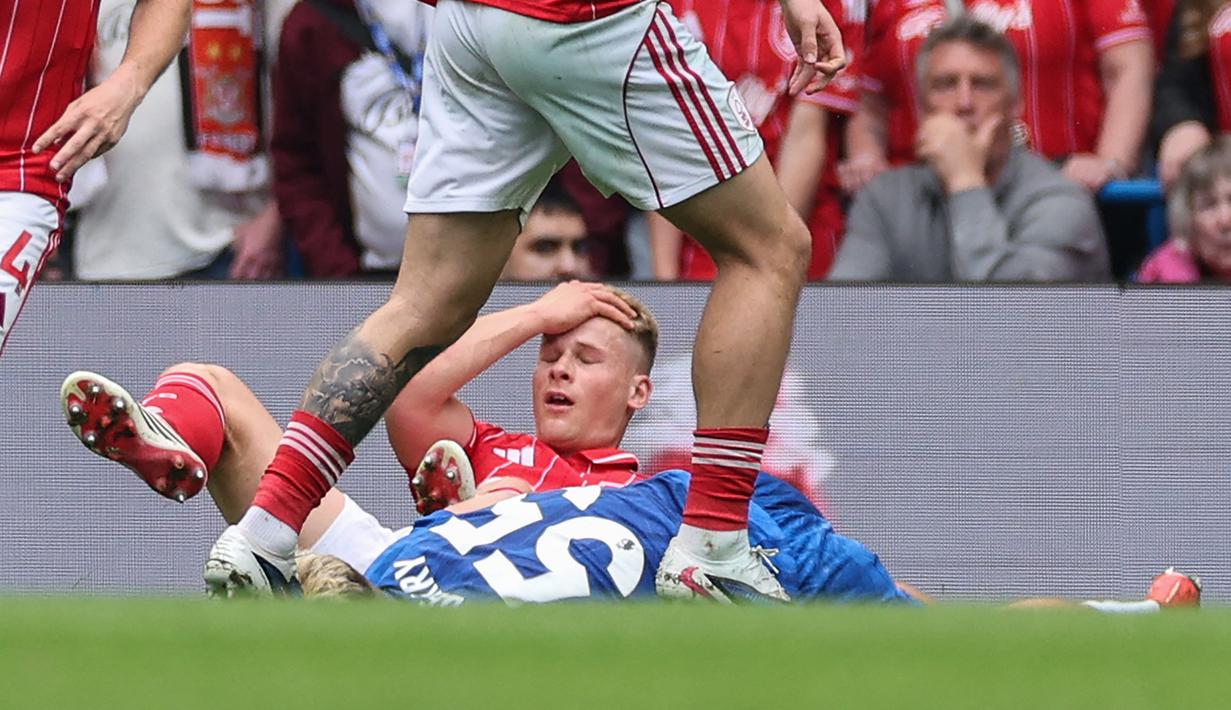 Pemain Chelsea, Jesse Derry terbaring di lapangan usai bertabrakan dengan pemain Nottingham Forest, Zach Abbott pada laga pekan ke-35 Premier League di Stamford Bridge, Senin (4/5/2026). (AFP/Adrian Dennis)