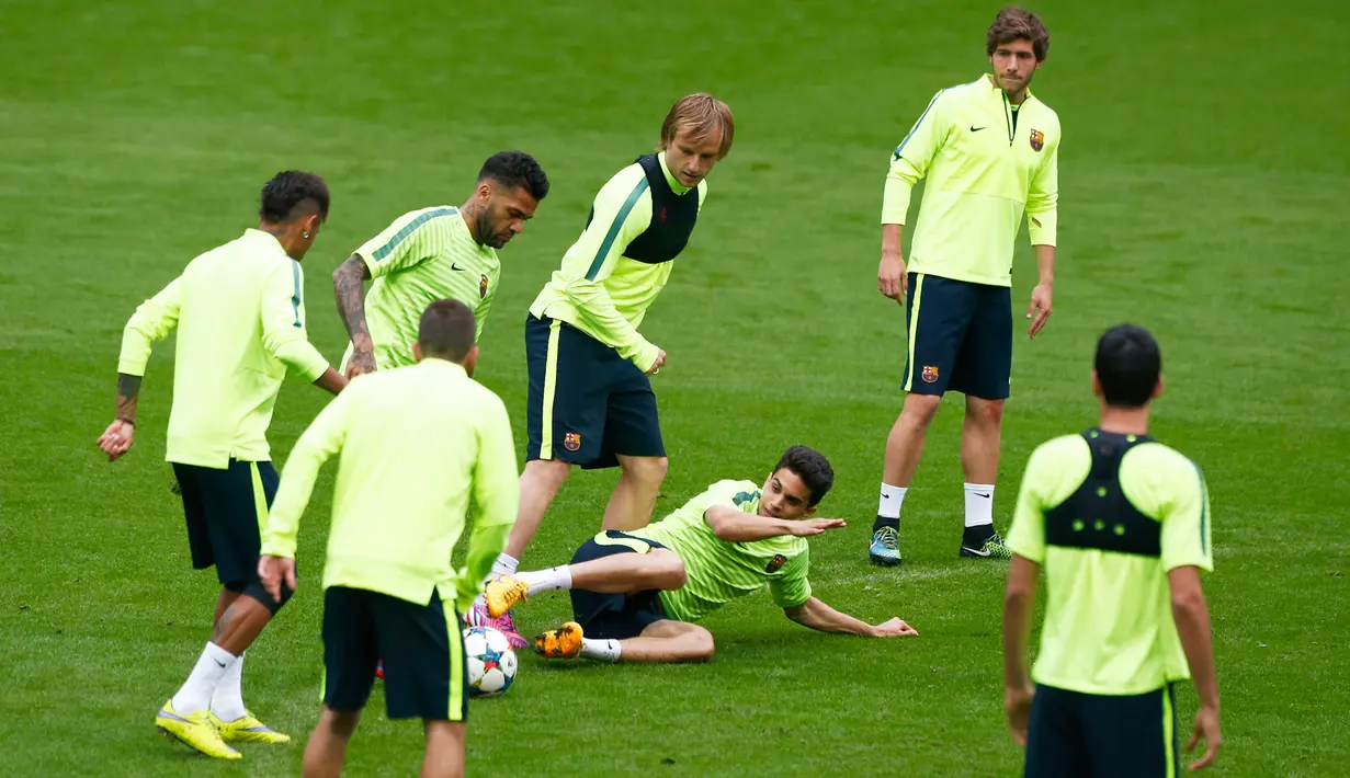 Bek Barcelona, Marc Bartra (bawah) berusaha merebut bola dari kaki Dani Alves saat sesi latihan di Allianz Arena, Munich, Jerman (11/5/2015).  Barcelona akan menantang Bayern Muenchen di leg kedua semifinal Liga Champions. (Reuters/Michaela Rehle)
