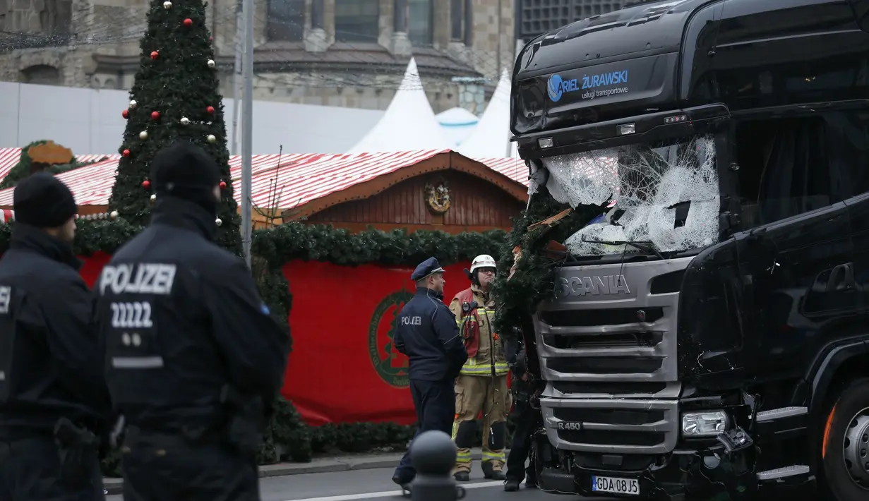 Petugas memeriksa kondisi truk yang menabrak Pasar Natal di Berlin, Jerman, Selasa (20/12). Akibat kejadian ini, dikabarkan 12 orang tewas dan 48 orang terluka. (REUTERS / Hannibal Hanschke)