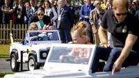 Meghan Markle dan Pangeran Harry bersama anak-anak naik mobil mainan di The Invictus Games di Den Haag pada 16 April 2022. (KOEN VAN WEEL / ANP / AFP)