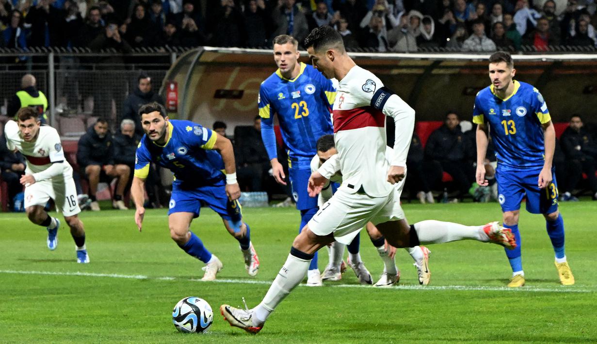 Striker Timnas Portugal, Cristiano Ronaldo mencetak gol pertama ke gawang Bosnia Herzegovina lewat eksekusi penalti pada laga lanjutan Grup J Kualifikasi Euro 2024 di Stadion Bellino Polje, Selasa (17/10/2023) dini hari WIB. (AFP/Elvis Barukcic)