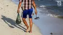 Warga berjalan membawa hasil tangkapan kerang di pesisir pantai Pulau Pasir, Lombok Timur, Sabtu (3/8/2019). Mereka menangkap kerang untuk dikonsumsi dengan menggunakan alat sederhana yang dibuat dengan besi menyerupai garpu. (Liputan6.com/Fery Pradolo)