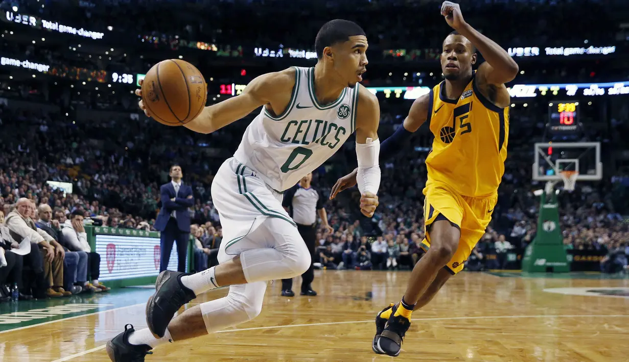 Pemain Boston Celtics, Jayson Tatum (0) menggiring bola melewati adangan pemain Utah Jazz, Rodney Hood (5) pada lanjutan NBA basketball game di TD Garden, Boston, (15/12/2017). Utah Jazz menang 107-95. (AP/Michael Dwyer)