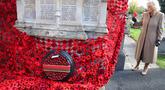 Ratu Inggris, Camilla, memasang bunga poppy terakhir untuk melengkapi rangkaian 10.000 bunga poppy yang menghiasi menara gereja di Gereja St. Bartholomew di Corsham, Inggris, pada Selasa 28 Oktober 2025. Kunjungan ini menjadi bagian dari kunjungan Ratu Inggris, Camilla, ke The Poppy Project. (Chris Jackson/POOL/AFP)