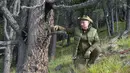 Presiden Rusia, Vladimir Putin berpose ketika menghabiskan waktu di kawasan hutan pegunungan Siberia, pada 6 Oktober 2019. Presiden Vladimir Putin menikmati hari lahirnya dengan mendaki pegunungan dan memetik jamur liar pada akhir pekan lalu. (Alexey DRUZHININ / Sputnik / AFP)