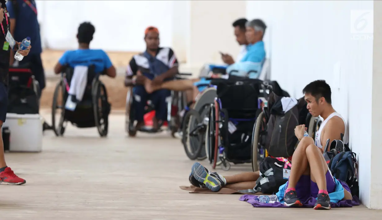 Sejumlah atlet terlihat duduk santai di Stadion Madya Kompleks Gelora Bung Karno, Jakarta, Kamis (11/10). Berbagai aktivitas dilakukan para atlet para atletik di luar arena. (Liputan6.com/Helmi Fithriansyah)