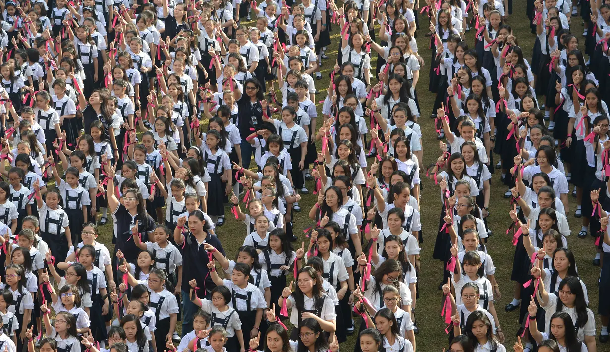 Siswa dari St. Scholastica's College mengambil bagian dalam gerakan One Billion Rising di Manila, Filipina, Kamis (14/2). Lebih dari 3.000 siswa berpartisipasi dalam acara yang digelar yang bertepatan dengan Hari Valentine tersebut. (TED ALJIBE/AFP)