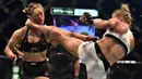 Tendangan dari Holly Holm, mendarat di kepala Ronda Rousey, perebutan gelar juara kelas bantam UFC Women di Stadion Etihad, Melbourne, Minggu (15/11/2015). Rousey, kalah KO dari Holm. (AFP Photo/Paul Crock)