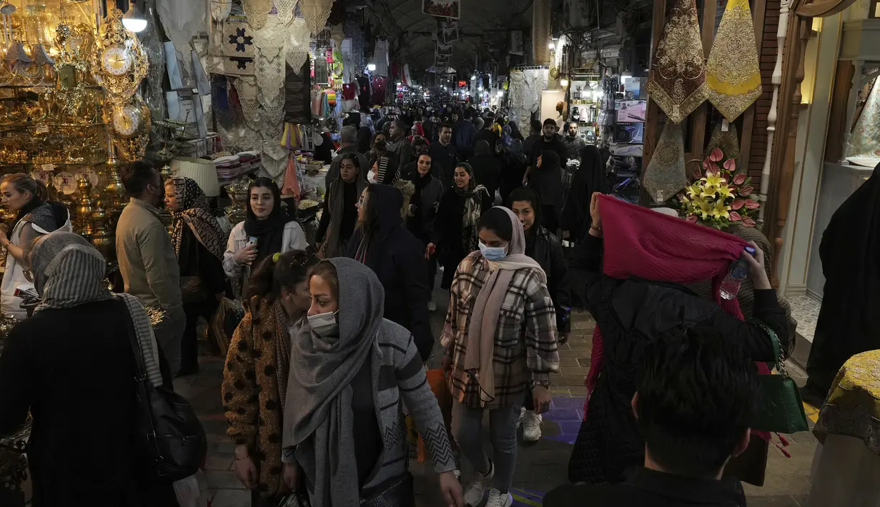 Orang-orang berbelanja di bazaar bersejarah tua Teheran, Iran, Minggu (26/2/2023). Anjloknya mata uang Rial menimbulkan terjadinya antrean panjang warga di kantor-kantor valuta asing yang berupaya mendapatkan mata uang dolar yang semakin langka. (AP Photo/Vahid Salemi)