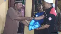 Keuchik Gampong Dayah Tuha Beuracan, Fauzi menerima santunan untuk istri mendiang anggota Polres Aceh Utara, Bripka Anumerta Faisal secara simbolis dari Dinsos Aceh. (Istimewa/JawaPos.com)