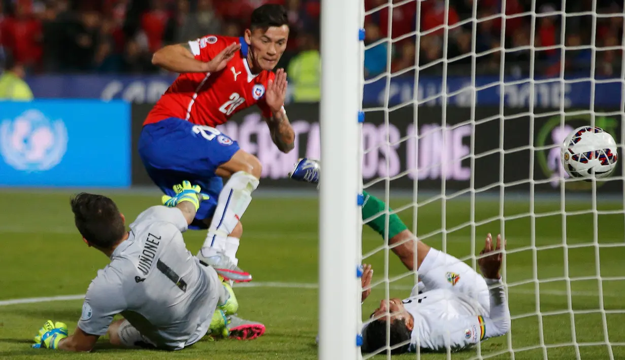 Kiper Bolivia, Romel Quinonez (kiri) gagal menghalau tendangan gelandang Chile Charles Aranguiz saat pertandingan Copa Amerika 2015 di Estadio Nacional, Santiago, Chile, (20/6/2015). Chile menang telak 5-0 atas Bolivia. (REUTERS/Henry Romero)