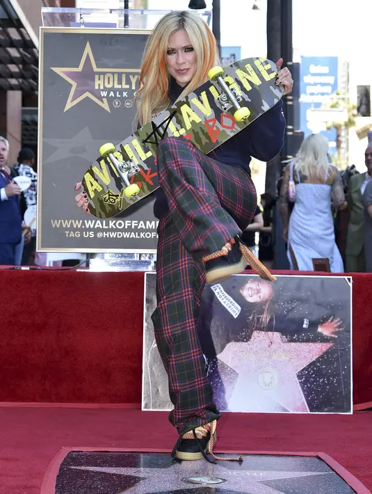 Penyanyi Avril Lavigne, memegang papan skateboard saat menghadiri upacara  penghargaan bintang Hollywood Walk of Fame di Los Angeles, Rabu (31/8/2022). Delapan nominasi Grammy Award dan delapan Juno Awards, termasuk Artist of the Year menjadi bukti bahwa Avril Lavigne pantas menerima bintang Walk of Fame. (Photo by Richard Shotwell/Invision/AP)