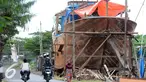 Warga melintas di area pembuatan perahu di Balongan, Indramayu, Jawa Barat, Jumat (15/1/2016). Dibutuhkan waktu selama delapan bulan untuk menyelesaikan satu unit perahu yang dijual seharga Rp.4 miliar - Rp.5 miliar tersebut. (Liputan6.com/Helmi Afandi)