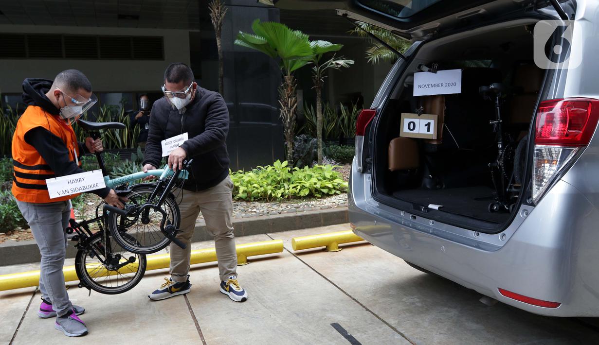 Tersangka Harry van Sidabuke (kiri) menyerahkan sepeda Brompton kepada perantara anggota Komisi II DPR Ihsan Yunus, Agustri Yogasmara saat rekonstruksi perkara dugaan korupsi pengadaan bantuan sosial penanganan COVID-19 di gedung KPK, Jakarta, Rabu (10/2/2021). (Liputan6.com/Helmi Fithriansyah)