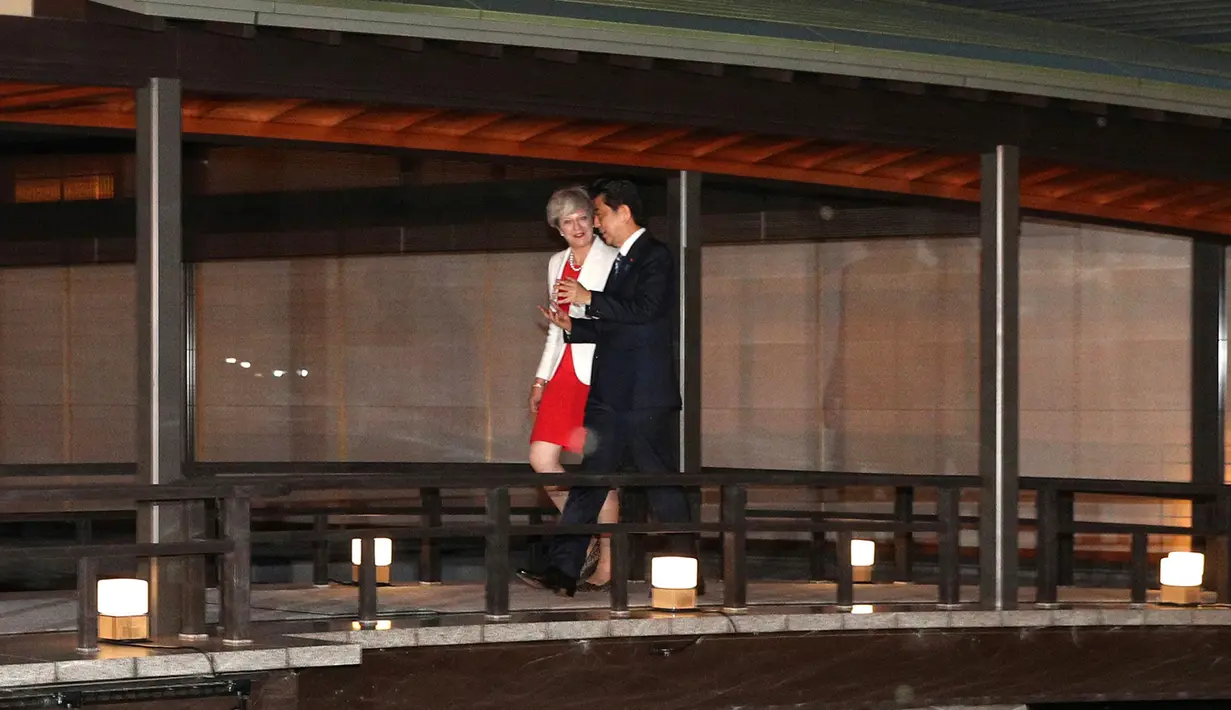 Perdana Menteri Inggris Theresa May berjalan bersama Perdana Menteri Jepang Shinzo Abe untuk acara makan malam di Kyoto, Jepang (30/8). Kedatangan PM Inggris itu untuk meredakan keresahan para pengusaha Jepang terkait Brexit. (Jumpei Teraguchi/Pool)