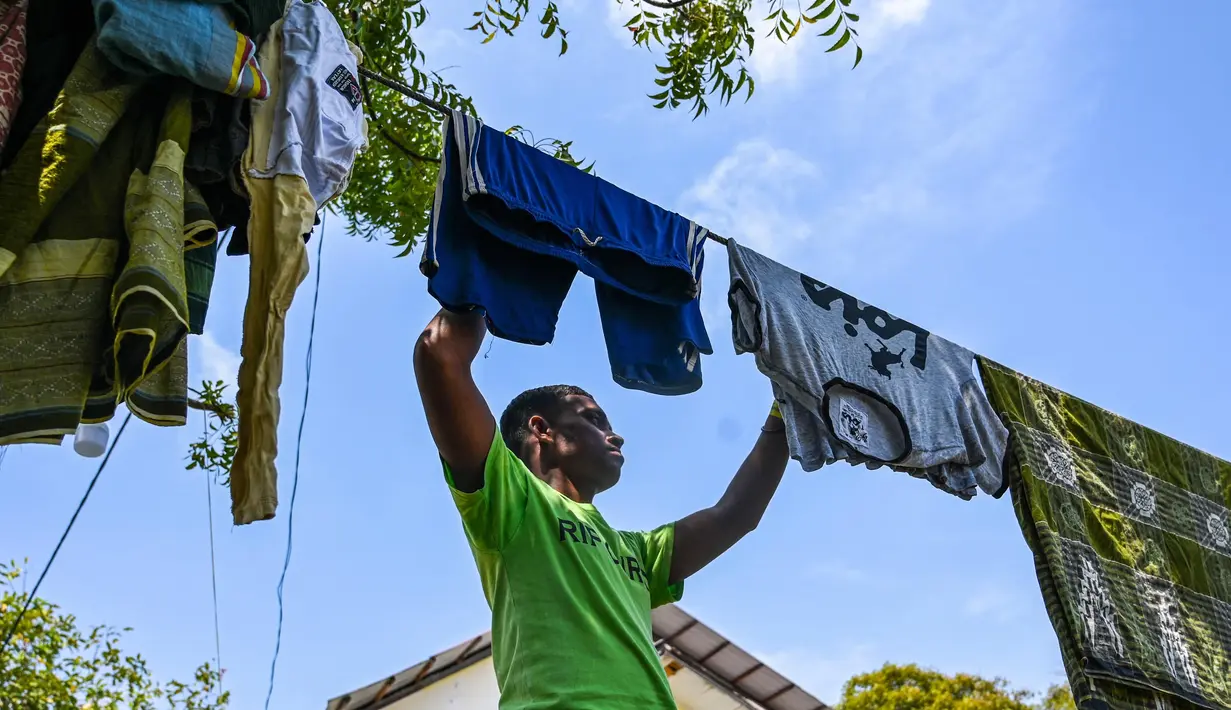Seorang pengungsi Rohingya menerima potongan rambut di tempat penampungan sementara di Ladong, provinsi Aceh, Jumat 24 Februari 2023. Sedikitnya 69 pengungsi Rohingya mendarat di pantai barat Indonesia pada 16 Februari lalu dengan sebuah perahu kayu, kata seorang pejabat badan pengungsi PBB. (CHAIDEER MAHYUDDIN/AFP)