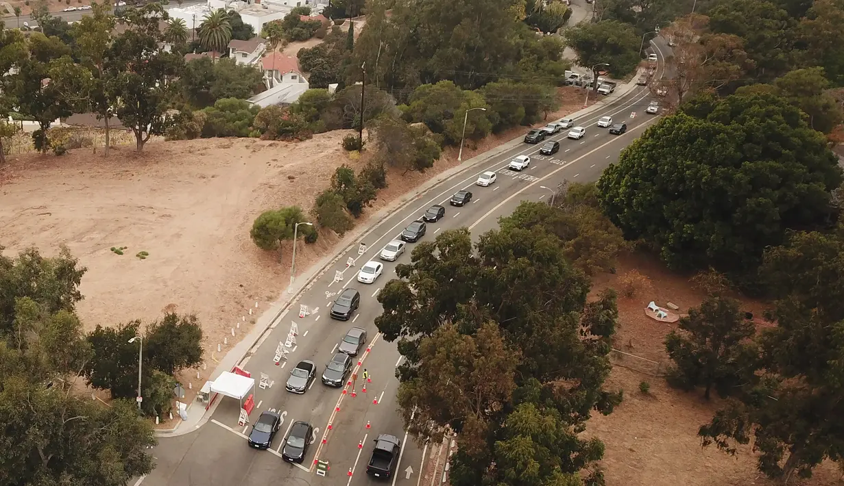 Pemandangan udara saat orang-orang antre di dalam mobil di lokasi pengujian Covid-19 drive-thru di Stadion Dodger di Los Angeles, California, Rabu (18/11/2020). Pejabat kesehatan Los Angeles County memperingatkan adanya peningkatan tajam dalam jumlah kasus COVID-19 dan rawat inap. (Robyn Beck/AFP)