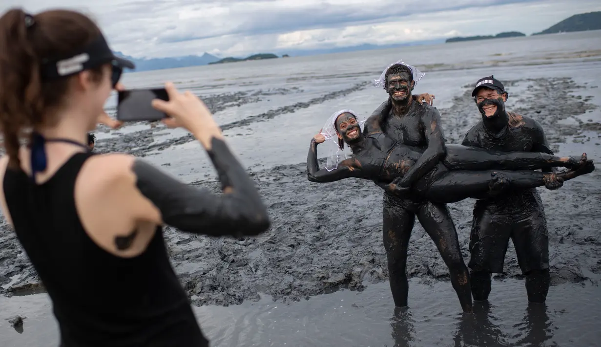 Sejumlah peserta foto bersama saat mengambil bagian dalam "Bloco da Lama", pesta mandi lumpur di Paraty, negara bagian Rio de Janeiro, Brasil (2/3). "Bloco da Lama" diketahui sudah ada sejak 1986 lalu. (AFP Photo/Mauro Pimentel)