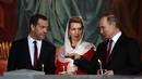 Presiden Rusia Vladimir Putin (kanan) bersama Perdana Menteri Rusia Dmitry Medvedev (kiri) dan istrinya Svetlana saat menjalani prosesi Paskah Ortodoks di Gereja Katedral Kristus Juru Selamat di Moskow, Rusia,(16/4). (AFP Photo / Vasily Maximov)