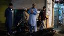 Para imigran Pakistan berkumpul untuk melakukan salat subuh usai menyantap sahur di distrik Kwai Chung, Hong Kong (25/5/2019). Kwai Chung adalah daerah perkotaan di dalam Kota Baru Tsuen Wan di Wilayah Baru Hong Kong. (AFP Photo/Philip Fong)