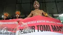 Sejumlah pemuda Papua mengenakan pakaian adat membentangkan spanduk di depan Gedung KPK, Jakarta, Senin (19/12). Mereka meminta KPK mengusut kasus korupsi pejabat yang mencalonkan diri pada Pilkada Jayapura 2017. (Liputan6.com/Helmi Affandi)