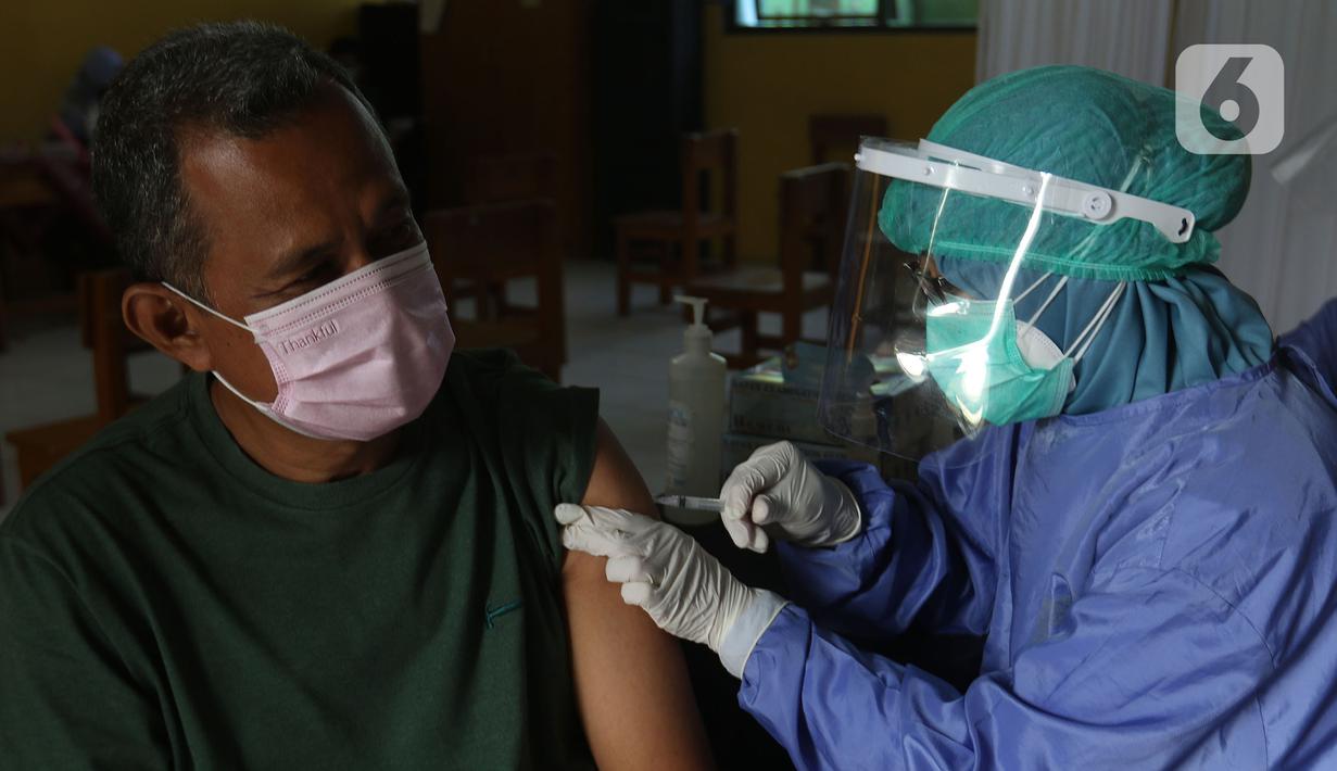 Tenaga kesehatan menyuntikan vaksin kepada warga di MTs As-Syafiiyah, Cilangkap, Jakarta, Kamis (3/6/2021). Vaksinasi akan menyasar sekitar 400 warga RT 03 RW 03 Cilangkap. (Liputan6.com/Herman Zakharia)