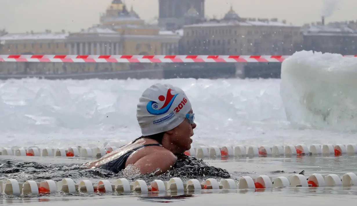Seorang wanita saat mengikuti kompetisi renang es Big Neva Cup di sungai Neva di St.Petersburg, Rusia, (3/3). Sekitar 150 peserta mengikuti kompetisi renang dengan suhu minus 10 derajat celcius. (AP Photo/Dmitri Lovetsky)