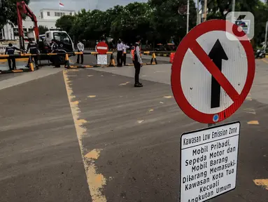 Petugas Dinas Perhubungan DKI Jakarta menurunkan beton barrier saat penutupan akses jalan menuju kawasan Kota Tua, Jumat (18/12/2020). Pemprov DKI membatasi moda transportasi melintasi kawasan wisata Kota Tua seiring penerapan kawasan rendah emisi atau Low Emission Zone. (Liputan6.com/Johan Tallo)