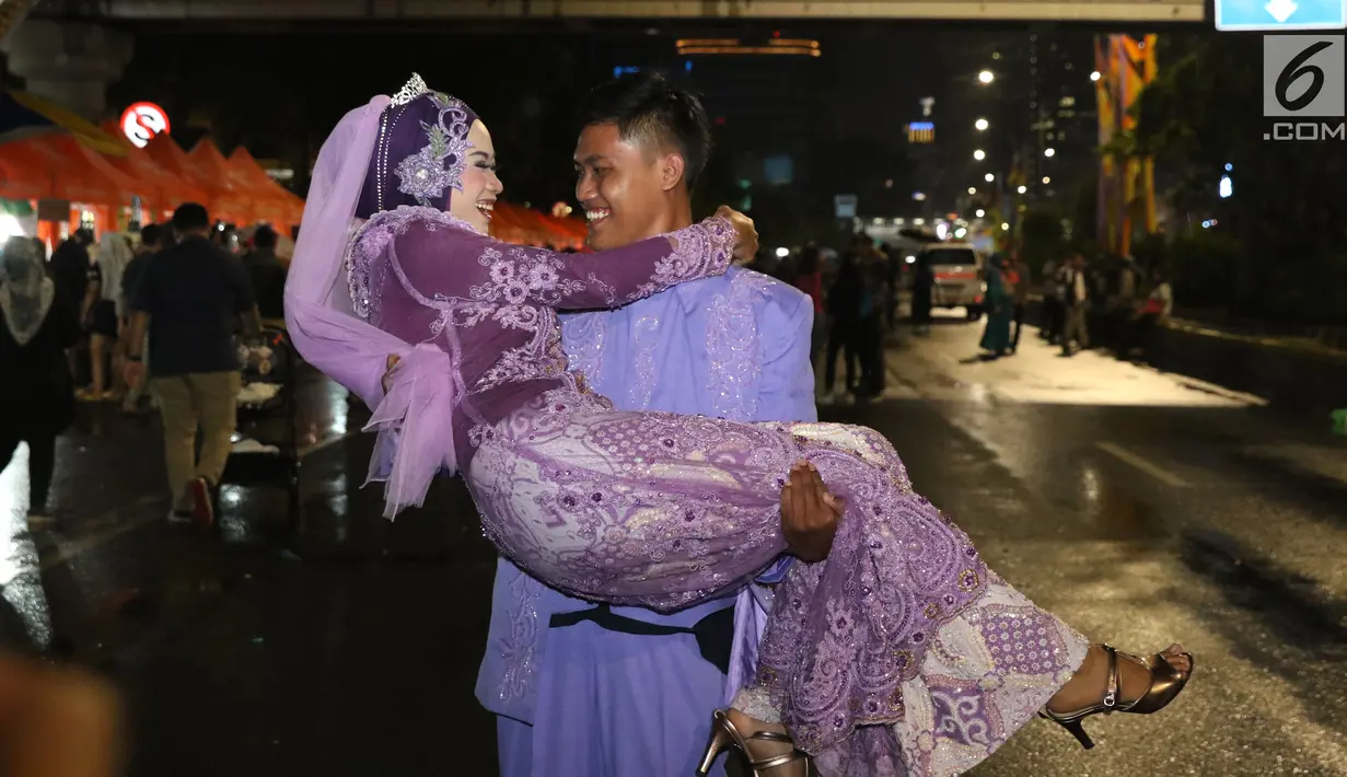 Pasangan Aldona Febrianti dan Septian Maulana meluapkan kebahagiaan usai ijab kabul di jalan MH Thamrin, Jakarta, Senin (31/12). 557 pasangan mengikuti nikah massal dan isbat nikah pada malam pergantian tahun 2018-2019. (Liputan6.com/Helmi Fithriansyah)