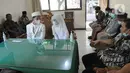 Sepasang pengantin yang menggunakan masker bersiap melakukan ijab-kabul di KUA Pamulang, Tangerang Selatan, Selasa (22/2/2022). Sebanyak 10 pasangan menjalankan akad nikah di KUA Pamulang pada hari ini yang dianggap memiliki tanggal cantik. (merdeka.com/Arie Basuki)
