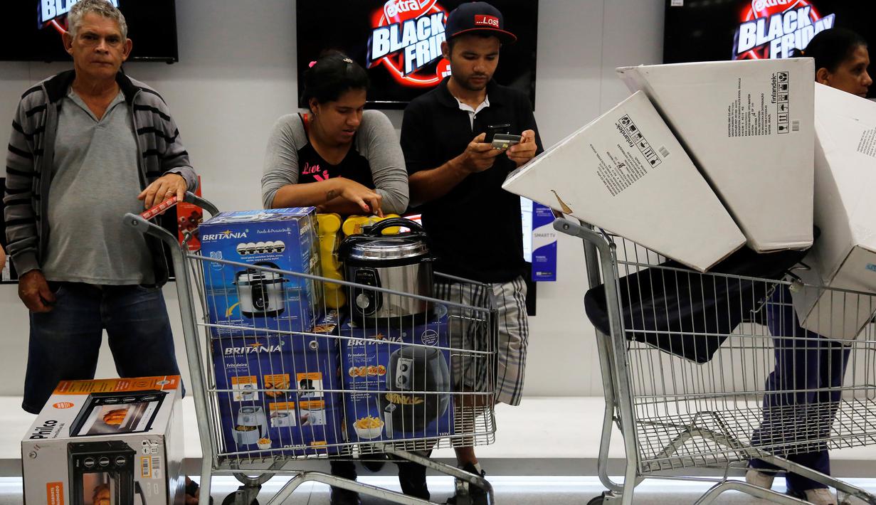 Pengunjung usai membeli barang elektronik pada hari "Black Friday" di sebuah toko di Sao Paulo, Brasil, (24/11). Black Friday menjadi penanda dimulainya musim berbelanja bagi warga Brasil menjelang Natal. (REUTERS/Andrew Kelly)