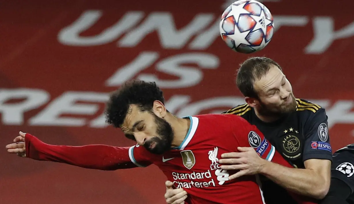 Bek Ajax Amsterdam, Daley Blind menggunakan kedua lengannya untuk menahan penyerang Liverpool, Mohamed Salah pada matchday kelima Grup D Liga Champions di Anfield, Selasa (1/12/2020). Curtis Jones mencetak gol satu-satunya yang membawa Liverpool melaju ke babak 16 besar. (Phil Noble/Pool via AP)