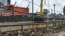 Petugas Sudin Kebersihan DKI Jakarta menurunkan alat berat untuk mengangkut sampah yang menumpuk di jembatan Kampung Melayu, Jatinegara, Jakarta Timur, Minggu (3/4/2016). (Liputan6.com/Yoppy Renato)