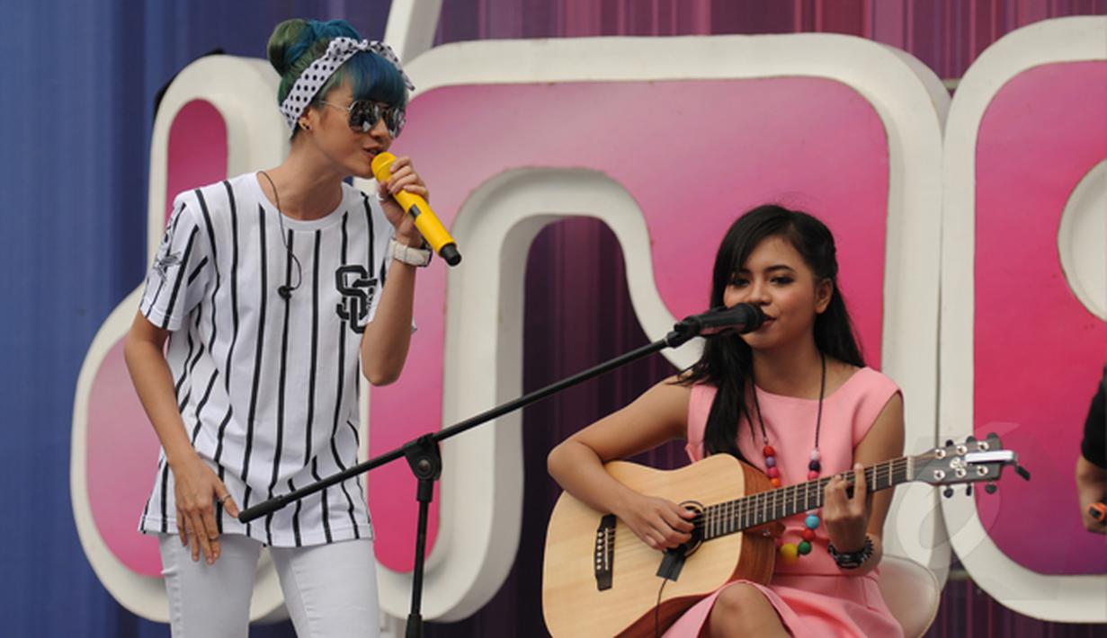 Pemenang keempat ajang Music Vidio Contest, Alif Ekacahya (kanan) berduet dengan Dara (personel The Virgin) saat tampil di panggung inBox SCTV di Cibinong, Bogor, Selasa (27/1/2015). (Liputan6.com/Helmi Fithriansyah)