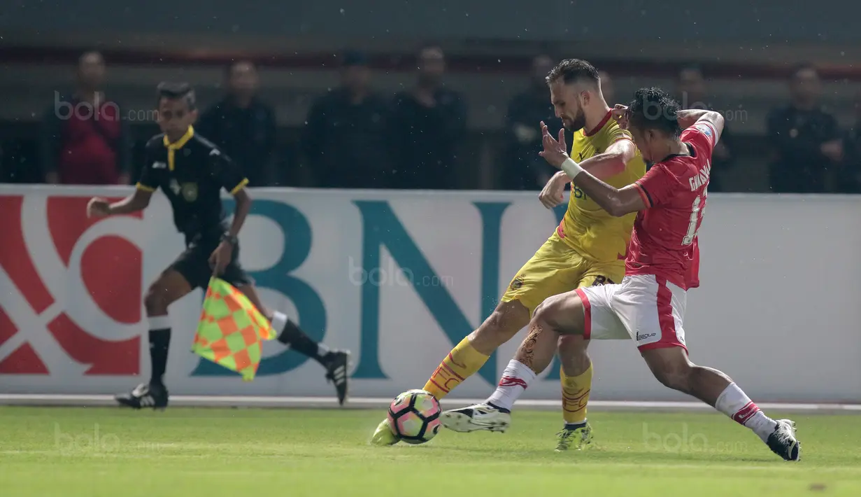 Pemain Bhayangkara FC, Ilija Spasojevic melewati adangan pemain Persija Jakarta, Gunawan Dwi Cahyo pada lanjutan Liga 1 2017 di Stadion Patriot Bekasi, Sabtu (12/11/2017). Bhayangkara kalah dari Persija 1-2. (Bola.com/Nicklas Hanoatubun)