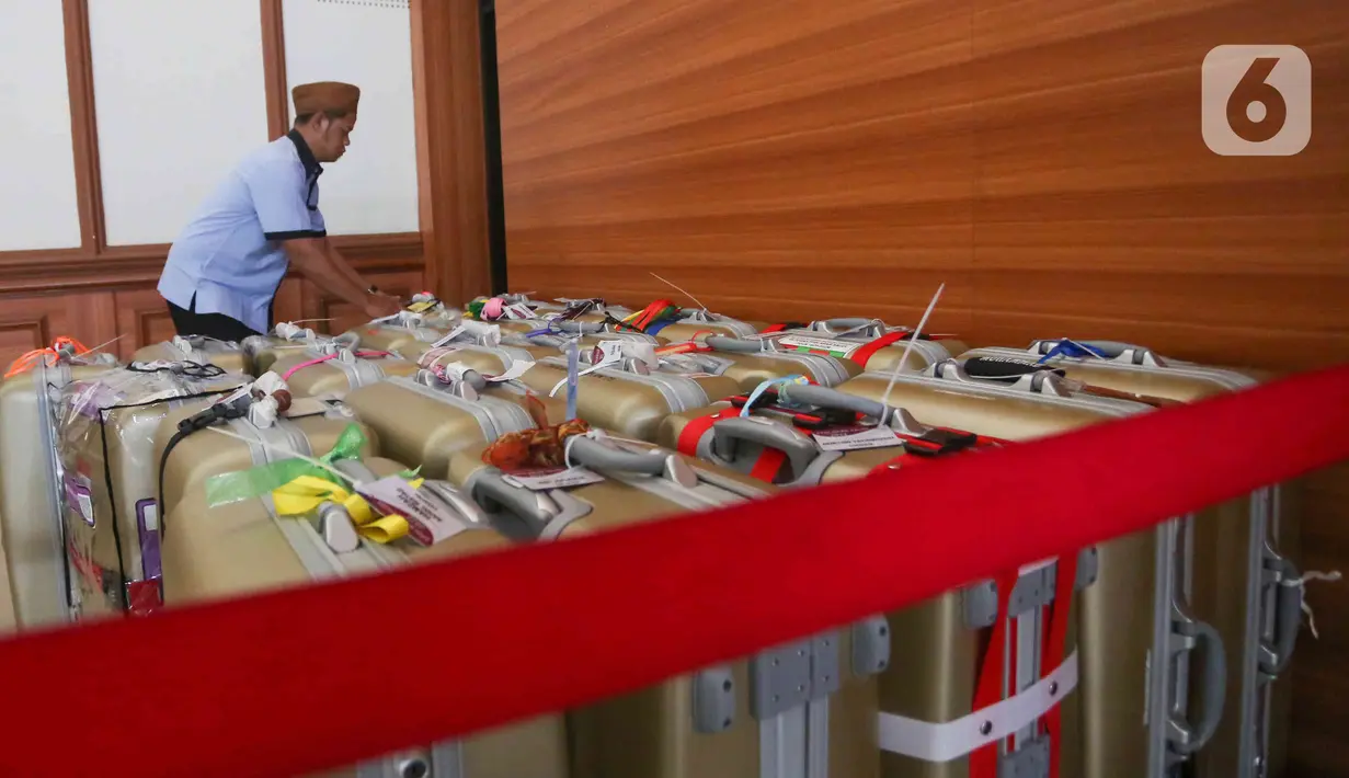 Petugas sedang merapikan koper petugas PPIH di asrama haji Pondok Gede, Jakarta, Selasa (31/5/2022). Petugas  PPIH (Petugas Panitia Penyelenggara Ibadah Haji) sebanyak di  828 orang di berangkatkan pada Rabu (1/6/2022) yang di bagi daerah kerja ke Jeddah, Madinah dan Mekkah. (Liputan6.com/Herman Zakharia)