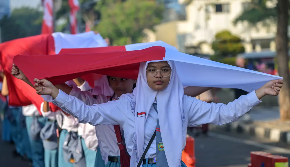 Ribuan pelajar turun ke jalan untuk mengikuti prosesi upacara dan arak-arakan bendera Merah Putih. (Juni KRISWANTO/AFP)