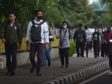 Karyawan perkantoran berjalan kaki  bergegas pulang di Kawasan Sudirman, Jakarta, Rabu (30/11/2022). Keputusan Pemerintah Provinsi (Pemprov) DKI Jakarta menaikan upah minimum provinsi (UMP) DKI  pada 2023 sebesar 5.6 persen menjadi Rp 4,9 juta . ditolak pengusaha dan buruh. (merdeka.com/Imam Buhori)