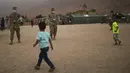 Anak-anak bermain sepak bola dengan pasukan militer AS di rumah sakit militer selama latihan militer Singa Afrika di Tafraout, Maroko, Kamis (10/6/2021). Dengan lebih 7.000 peserta dari sembilan negara dan NATO, Singa Afrika adalah latihan terbesar Komando Afrika AS. (AP Photo/Mosa'ab Elshamy)