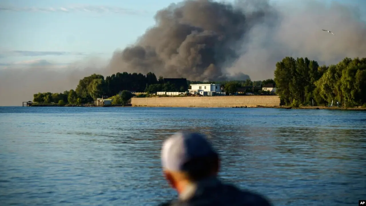 Seorang nelayan mengamati asap yang mengepul di seberangnya setelah pasukan Rusia melancarkan serangan misil ke Distrik Vyshhorod, di pinggiran Kota Kiev, Ukraina, pada 28 Juli 2022. (Foto: AP/David Goldman)
