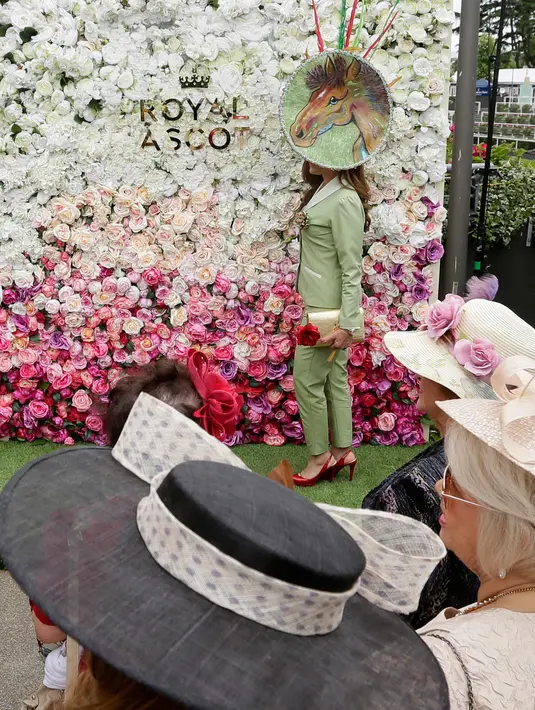 Racegoers dengan hiasan kepala berpose pada hari pertama ajang pacuan kuda Royal Ascot, Inggris, Selasa (19/6). Seperti biasanya, topi-topi cantik dan unik menjadi properti wajib bagi para bangsawan wanita yang hadir. (AP/Tim Ireland)