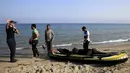 Petugas Pantai Yunani berbincang dengan para imigran Afghanistan yang tiba usai melintasi Laut Aegea antara Turki dan Yunani, (8/8/2015). PBB dan UNHCR memperkirakan bahwa Yunani telah menerima lebih dari 107.000 pengungsi. (REUTERS/Yannis Behrakis)