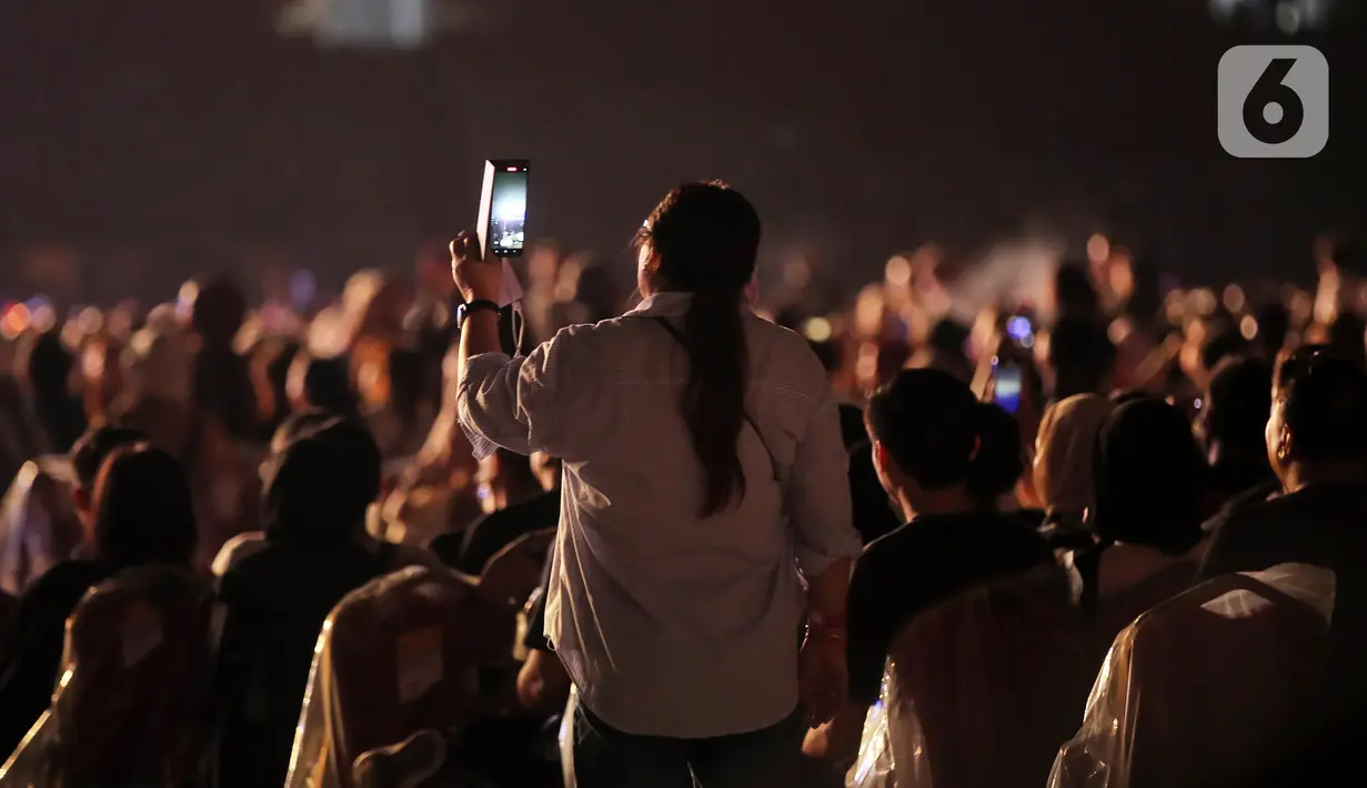 Penonton mengambil gambar konser bertajuk Raisa Live in Concert di Stadion Utama Gelora Bung Karno (SUGBK), Senayan, Jakarta, 25 Februari 2023. Konser Raisa yang sempat tertunda hampir tiga tahun karena pandemi COVID-19 ini mencetak sejarah sebagai penyanyi solo wanita yang mengadakan konser di (SUGBK). (Kapanlagi.com/Bambang E. Ros)