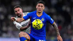 Kekalahan ini membuat Los Blancos gagal memangkas jarak dengan pimpinan klasemen La Liga, Barcelona. Tampak dalam foto, Martin Satriano dari Getafe (kanan) berebut bola dengan pemain Real Madrid, Dani Carvajal, saat pertandingan pekan ke-26 La Liga 2025/2026 di Stadion Bernabeu, Madrid, Spanyol, Senin 2 Maret 2026 waktu setempat atau Selasa (3/3/2026) dini hari WIB. (AP Photo/Manu Fernandez)